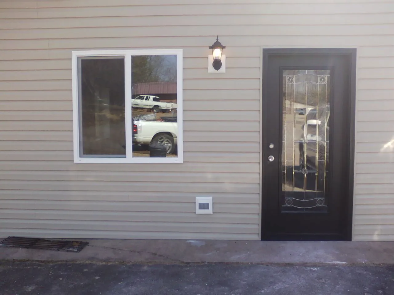 New siding, window and entry door on the side of an addition in White