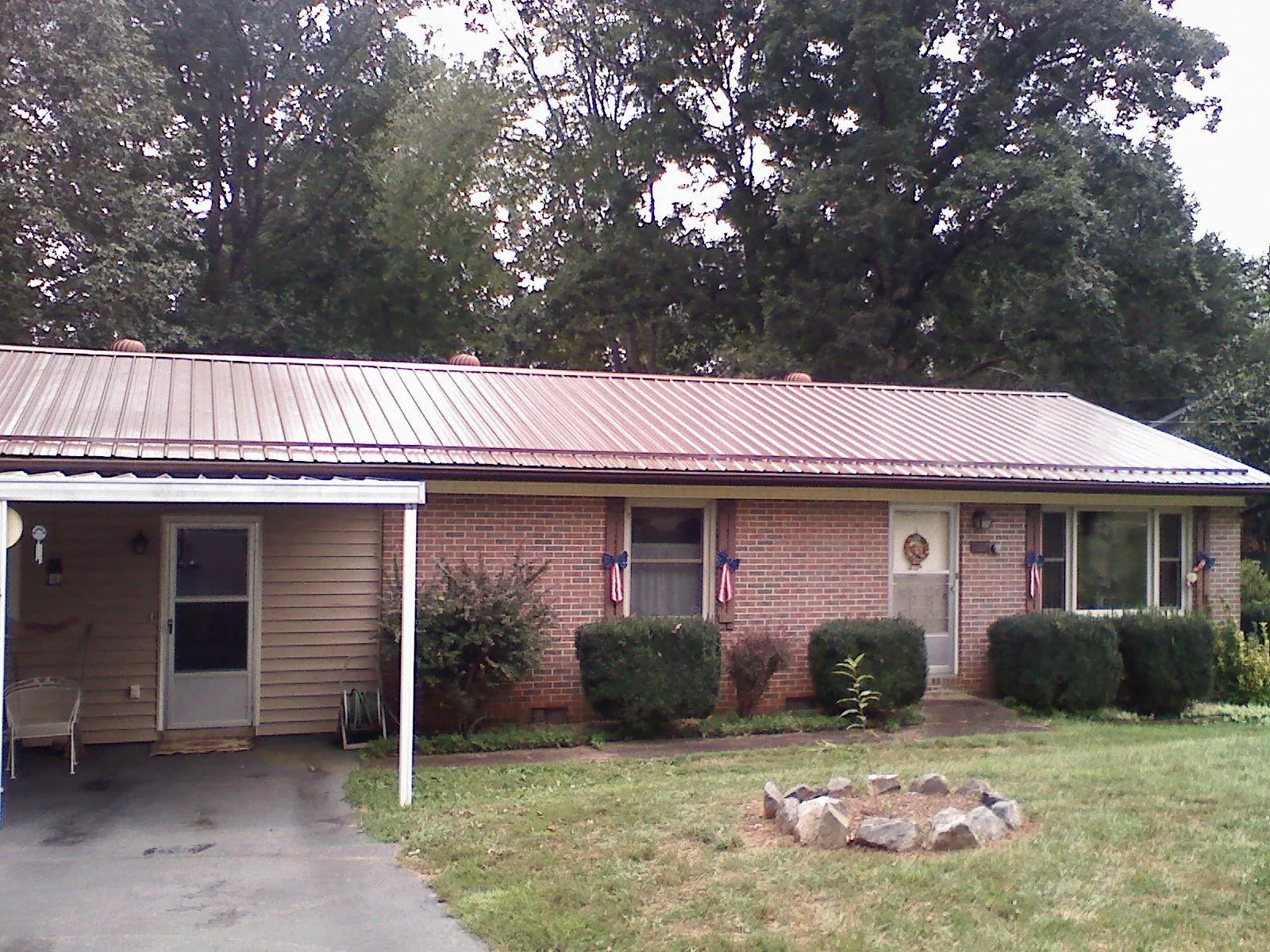 Bronze metal roof and carport on a brick ranch home — Roof Repair work by our crew in White